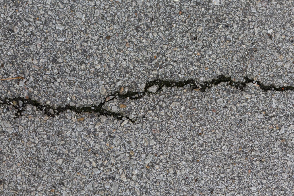 Six Types of Cracks in Your Asphalt that Require Immediate Repairs 10 cement surface with rocks crack 1
